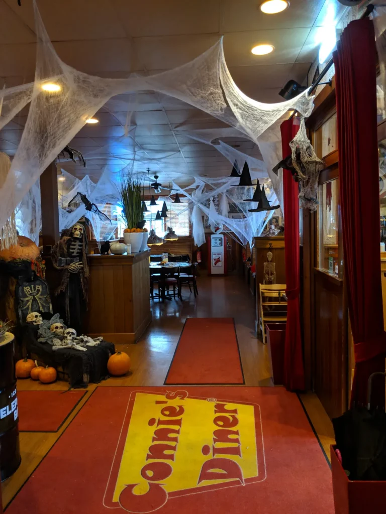 Eingangsflur mit Spinnweben, Kürbissen und der roten Connie’s-Diner-Fußmatte